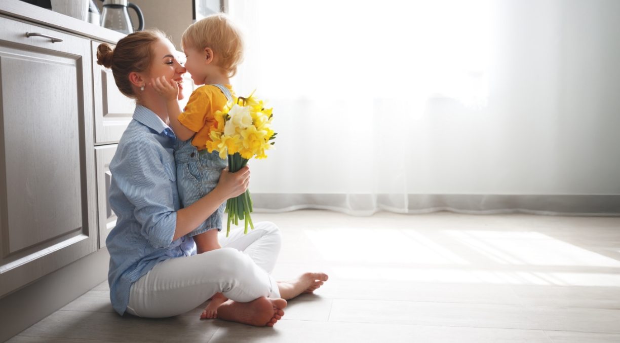 Mother and child sitting on the floor in the kitchen together